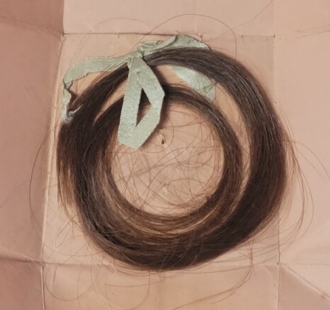 A lock of hair tied with a blue ribbon